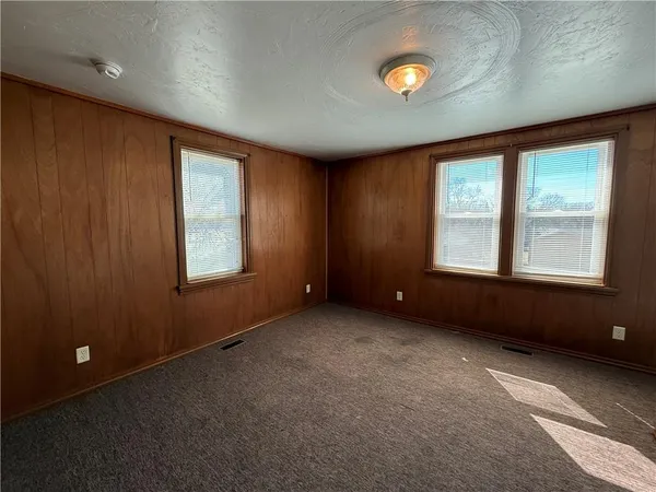 an empty room with windows and closet