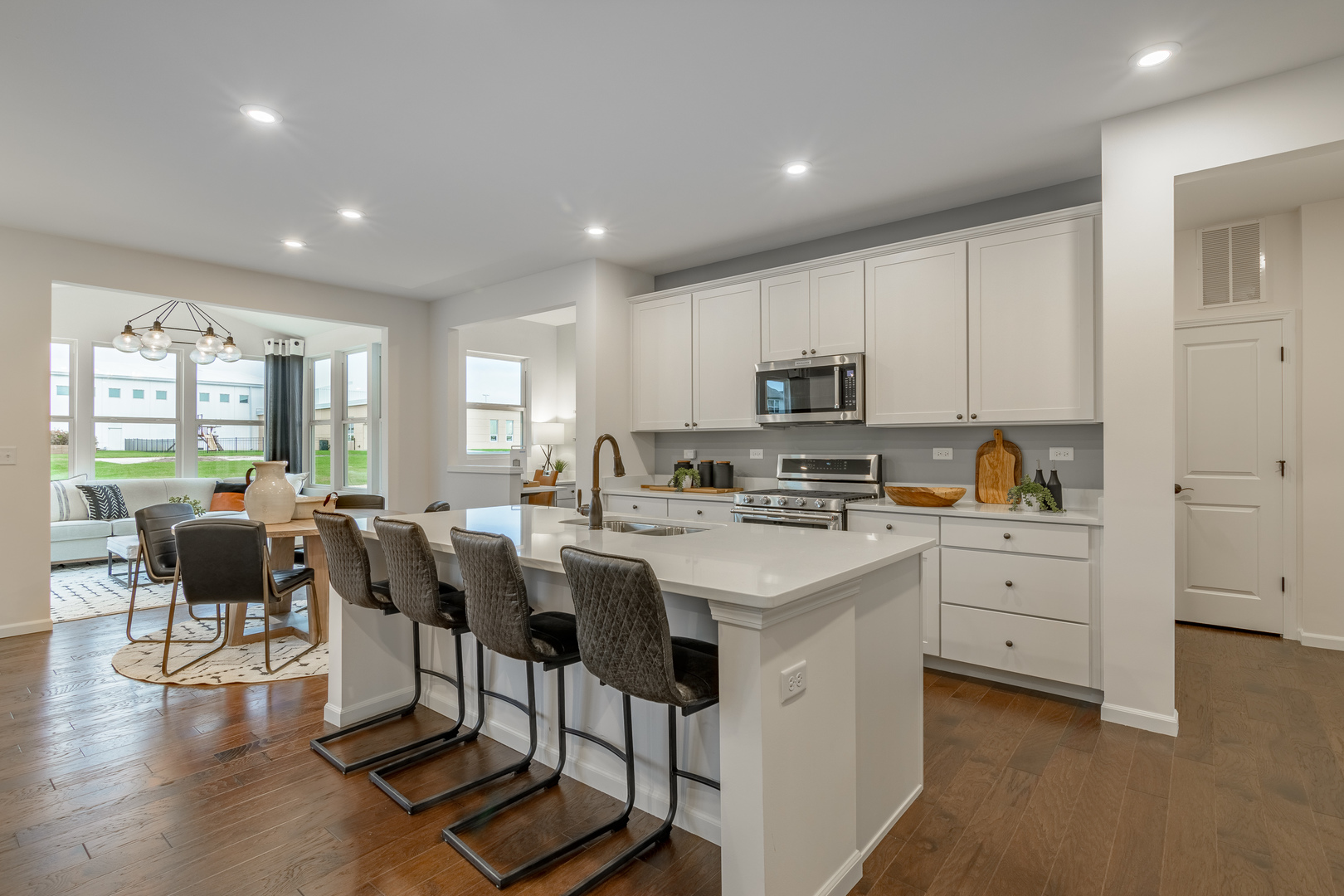 591 North Highlander Way Addison, IL 60101 - Photo 6 of 25 a kitchen with white cabinets and chairs