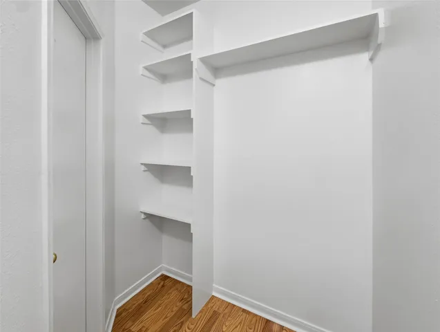 a view of walk in closet with empty racks