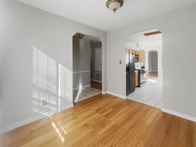 a view of a livingroom with wooden floor and kitchen