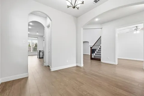 an empty room with wooden floor and a bathroom