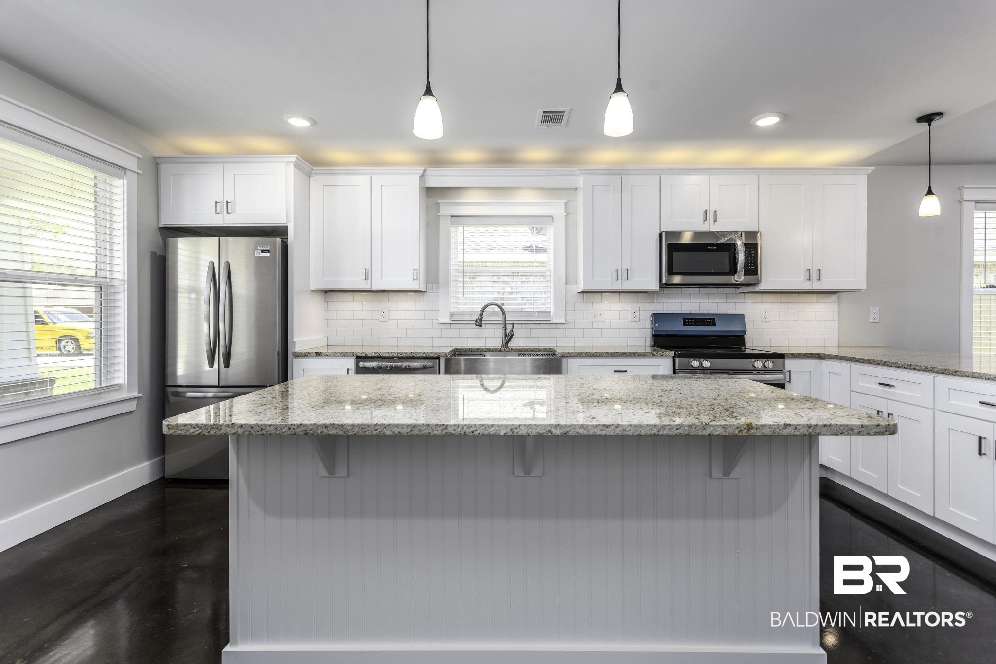 17126 Sugar Loop Foley, AL 36535 - Photo 4 of 28 Kitchen with appliances with stainless steel finishes, a breakfast bar area, white cabinets, tasteful backsplash, and pendant lighting