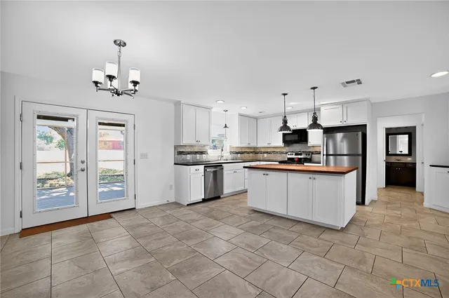 a kitchen with stainless steel appliances granite countertop a refrigerator and a stove top oven