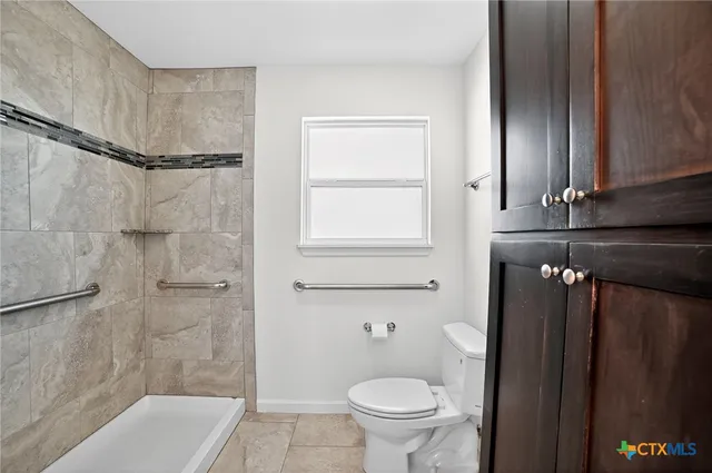 a bathroom with a granite countertop bathtub shower sink and toilet