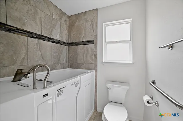 a bathroom with a sink a toilet and mirror