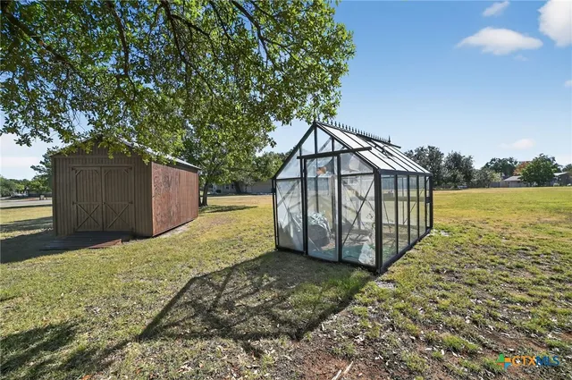 a view of a house with a yard and wooden fence