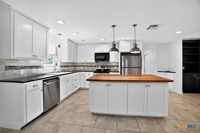 a kitchen with stainless steel appliances granite countertop a sink and cabinets