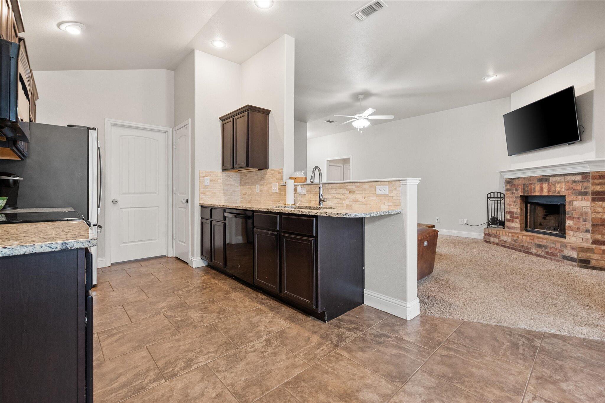 7026 97th Street Lubbock, TX 79424 - Photo 14 of 30 a kitchen with kitchen island a sink stainless steel appliances and cabinets