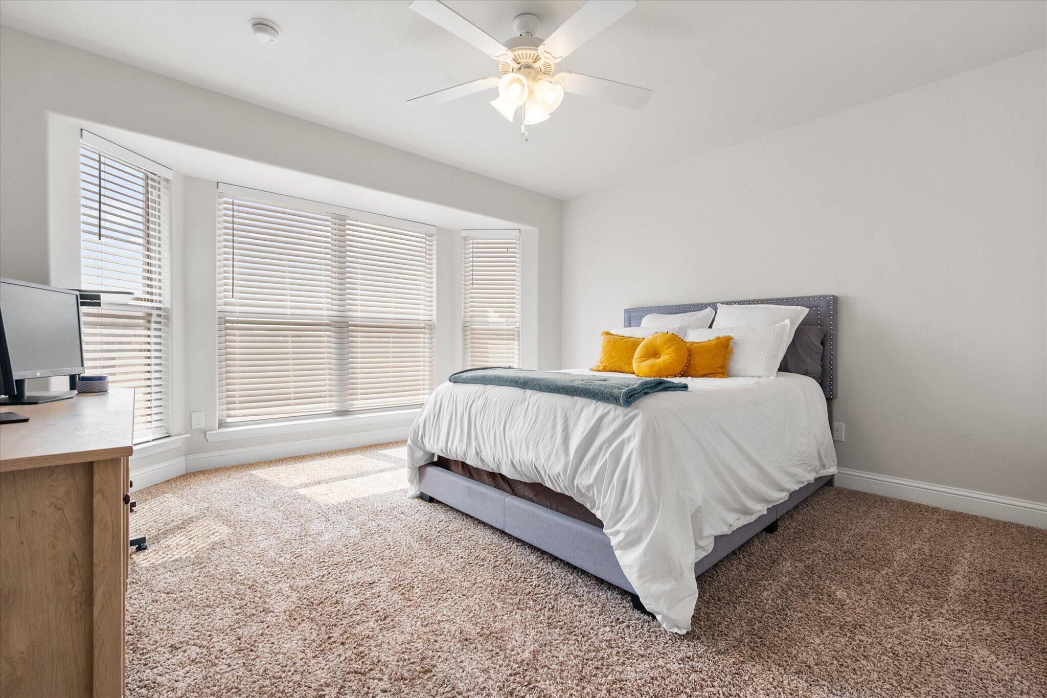 7026 97th Street Lubbock, TX 79424 - Photo 18 of 30 a bed sitting in a spacious bedroom next to a window