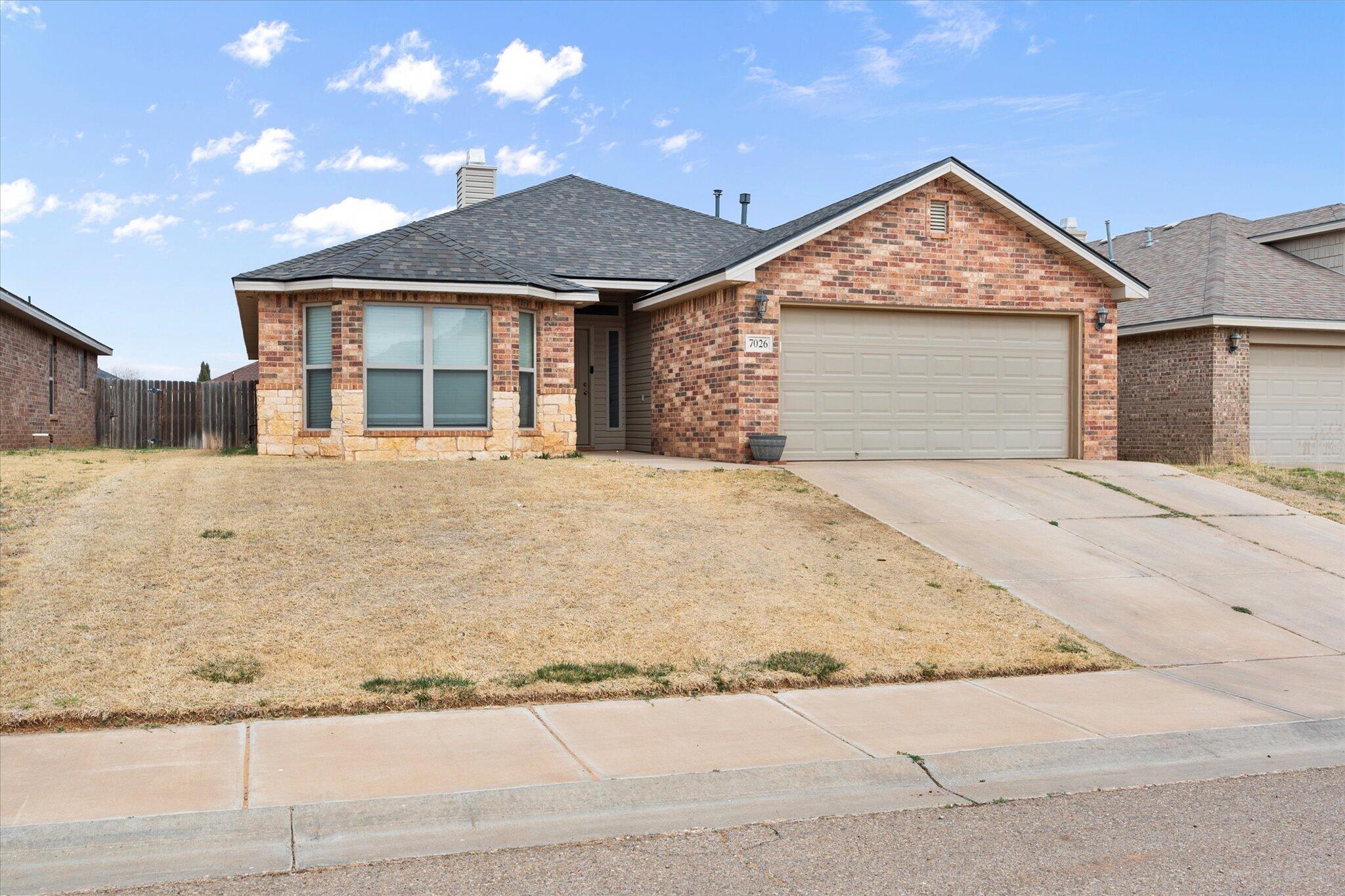 7026 97th Street Lubbock, TX 79424 - Photo 2 of 30 a front view of a house with a yard