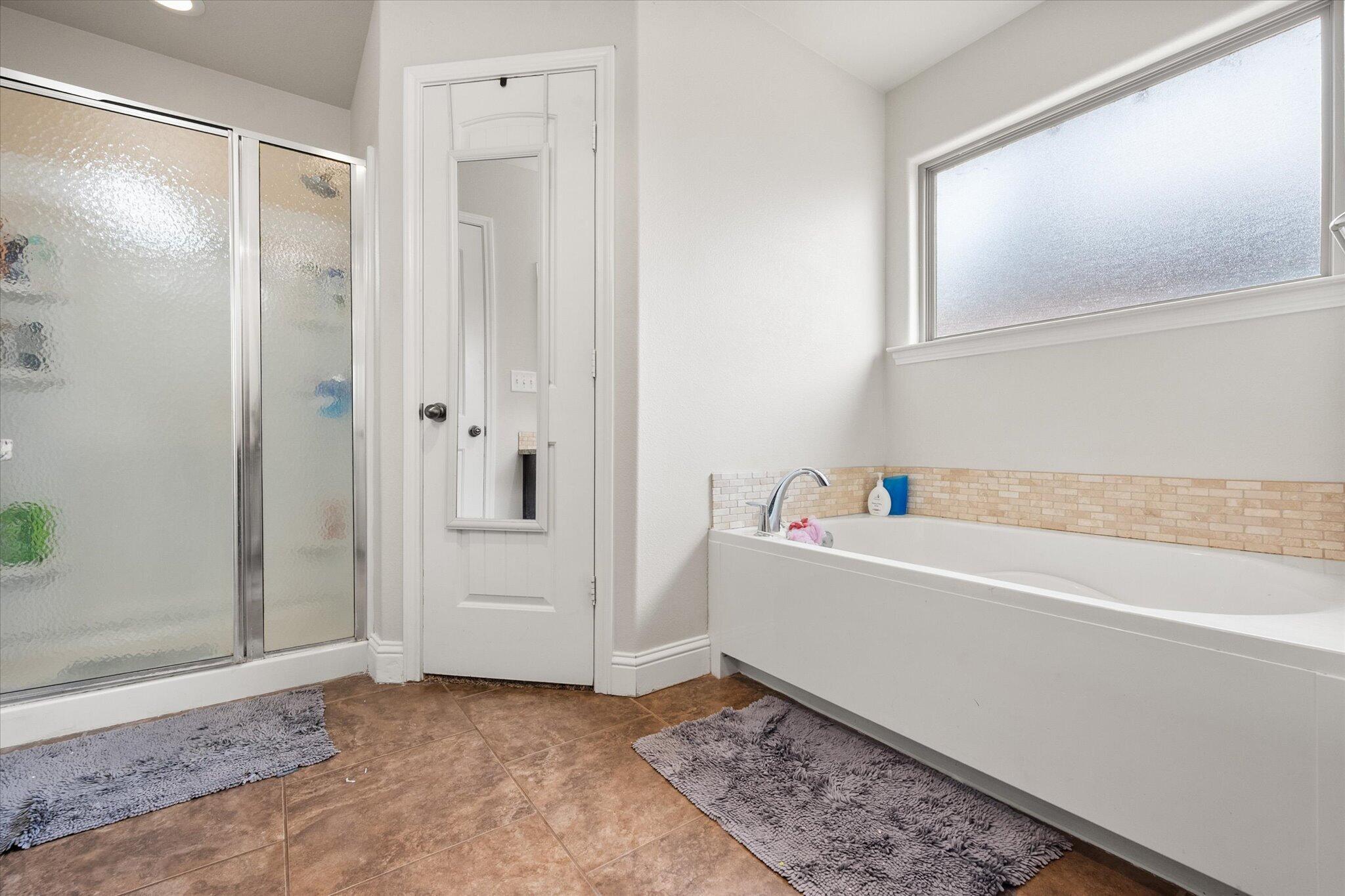7026 97th Street Lubbock, TX 79424 - Photo 25 of 30 a bathroom with a bathtub and a shower