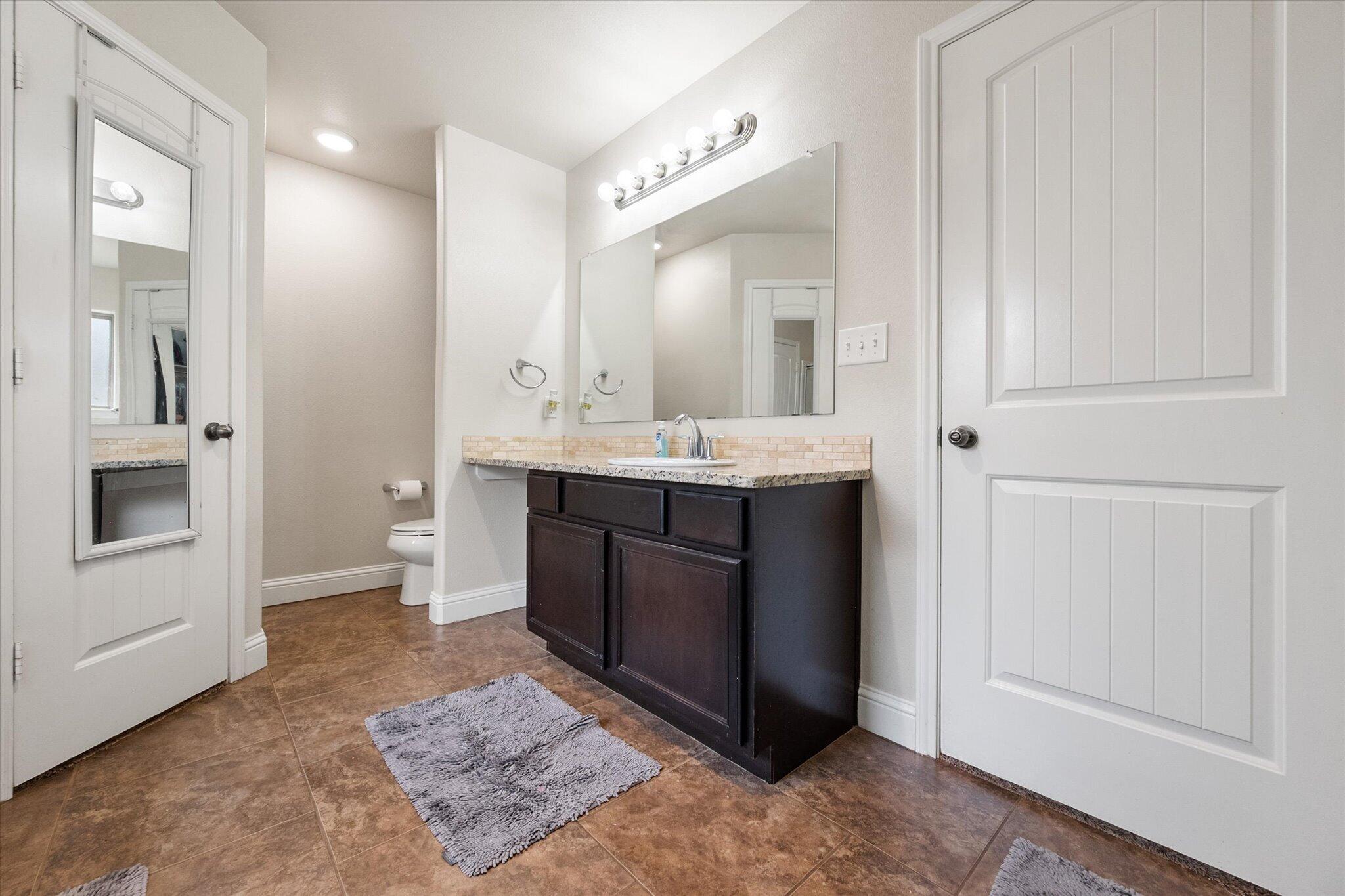 7026 97th Street Lubbock, TX 79424 - Photo 26 of 30 a bathroom with a sink and a mirror