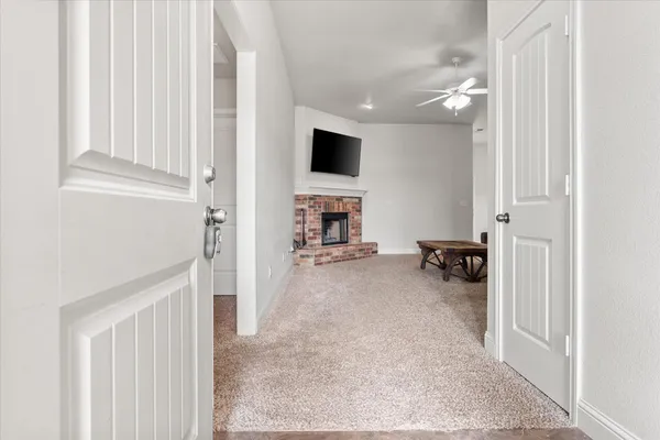 a living room with furniture a flat screen tv and kitchen view