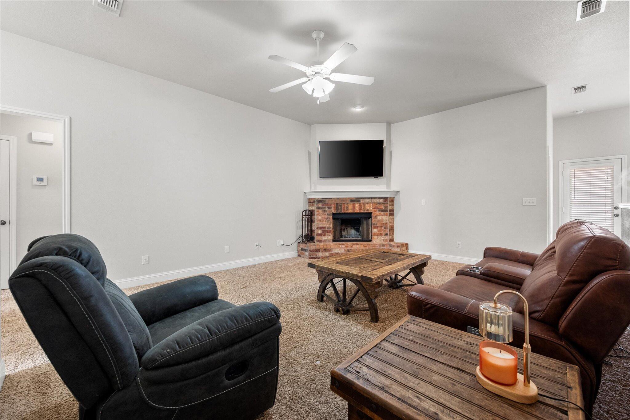 7026 97th Street Lubbock, TX 79424 - Photo 7 of 30 a living room with furniture a flat screen tv and kitchen view