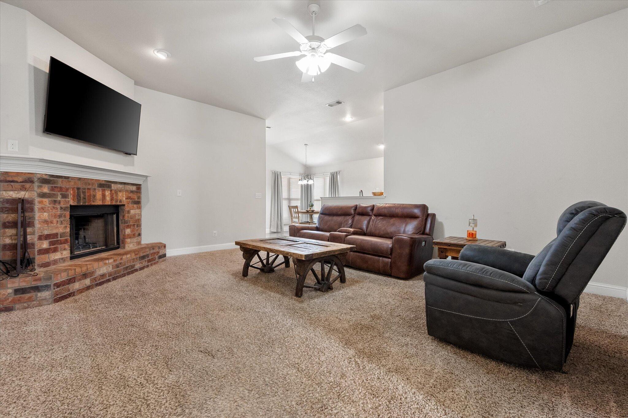 7026 97th Street Lubbock, TX 79424 - Photo 9 of 30 a living room with furniture and a fireplace