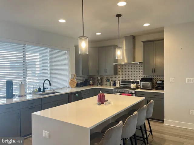 a kitchen with granite countertop a sink a counter space appliances and cabinets