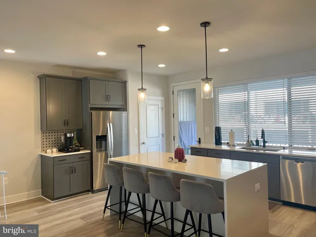 a kitchen with center island a sink stainless steel appliances and cabinets