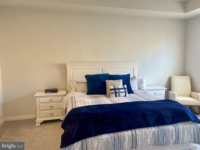 a bedroom with a large bed and a potted plant
