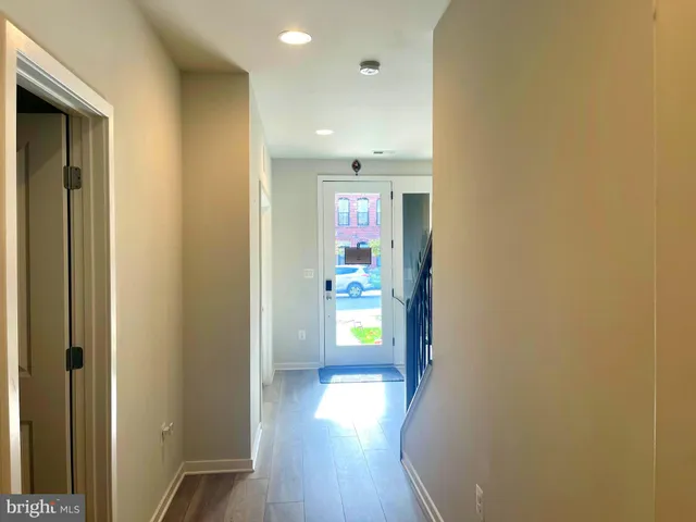 a view of a hallway with wooden floor and door