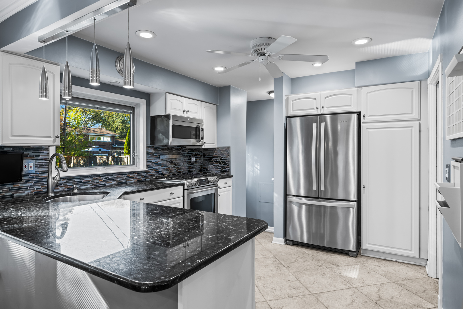 906 South Tower Lane Mount Prospect, IL 60056 - Photo 9 of 24 a kitchen with stainless steel appliances granite countertop a sink refrigerator and microwave