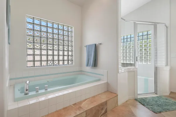 a spacious bedroom with a bed and a flat screen tv