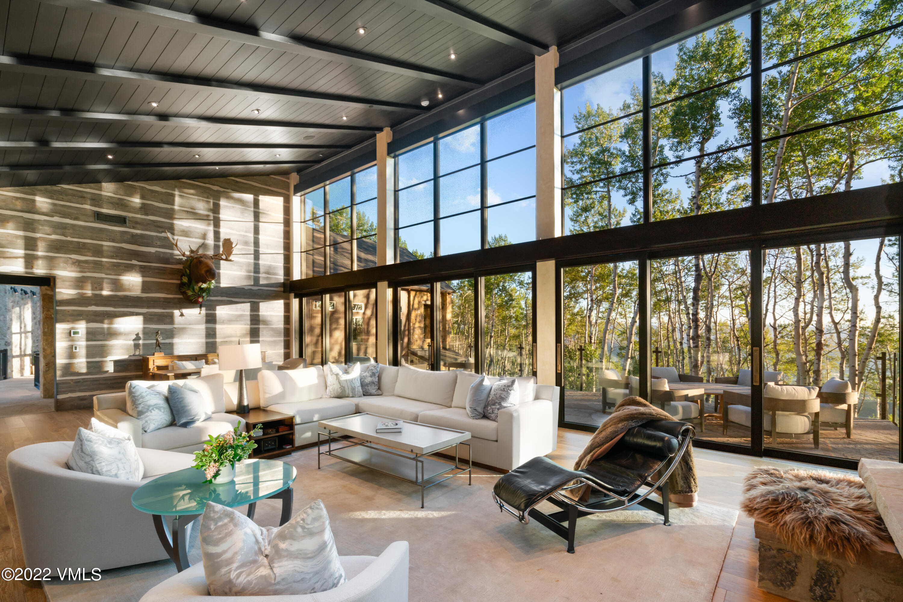 275 Wildrose Avon, CO 81620 - Photo 2 of 44 a living room with furniture floor to ceiling windows and a table