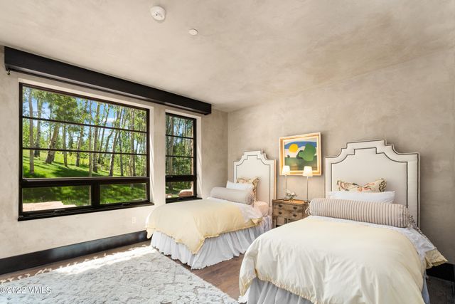 a bedroom with two beds and large window