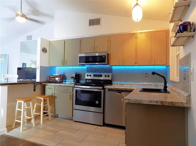 a kitchen with stainless steel appliances granite countertop a sink stove and refrigerator