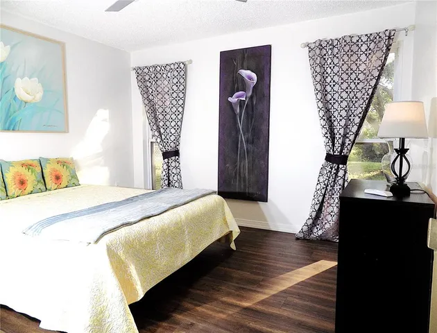 a bedroom with a bed and a table with wooden floor