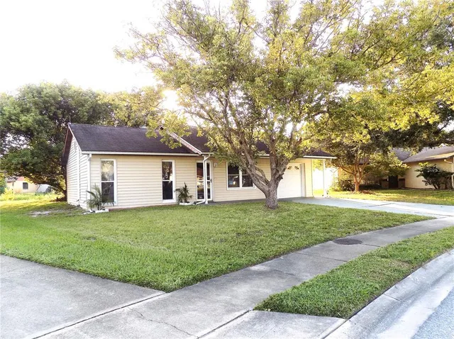 a front view of a house with a yard and trees