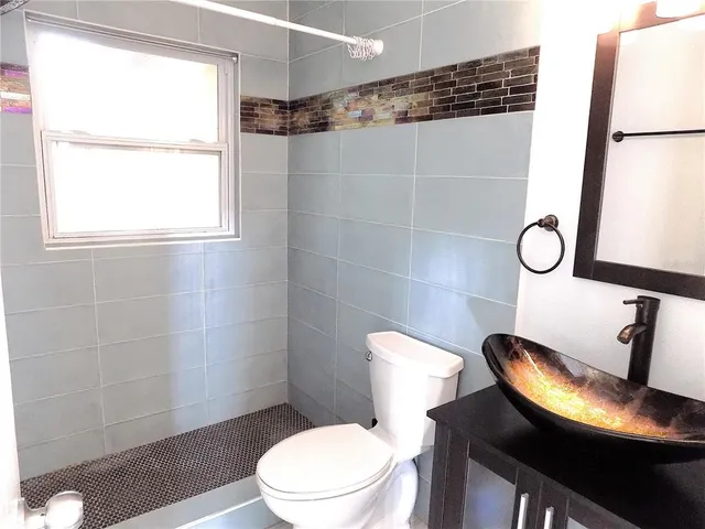 a white toilet sitting next to a bathroom sink and a shower