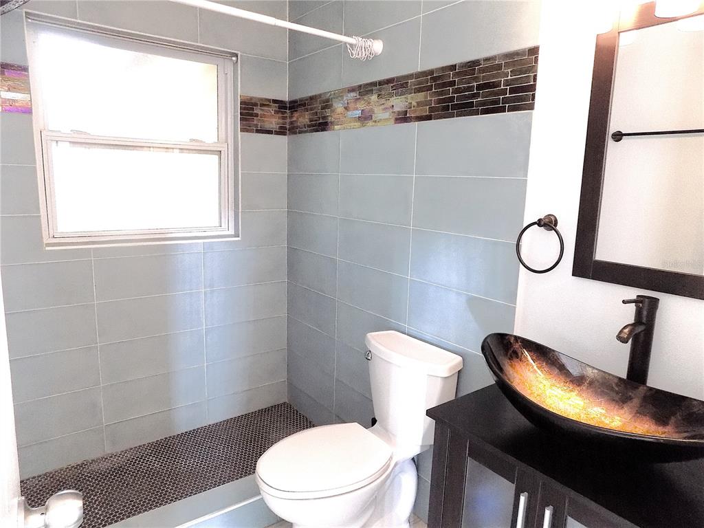 7344 Como Drive New Port Richey, FL 34655 - Photo 22 of 34 a white toilet sitting next to a bathroom sink and a shower