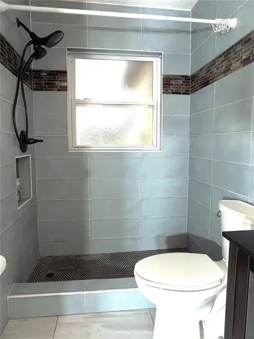 a bathroom with a toilet and a shower