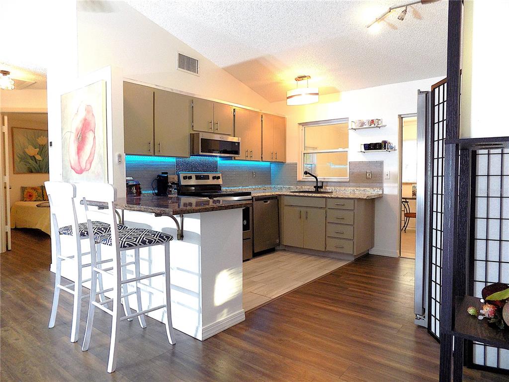 7344 Como Drive New Port Richey, FL 34655 - Photo 10 of 34 a kitchen with stainless steel appliances a sink a stove a refrigerator cabinets and wooden floor