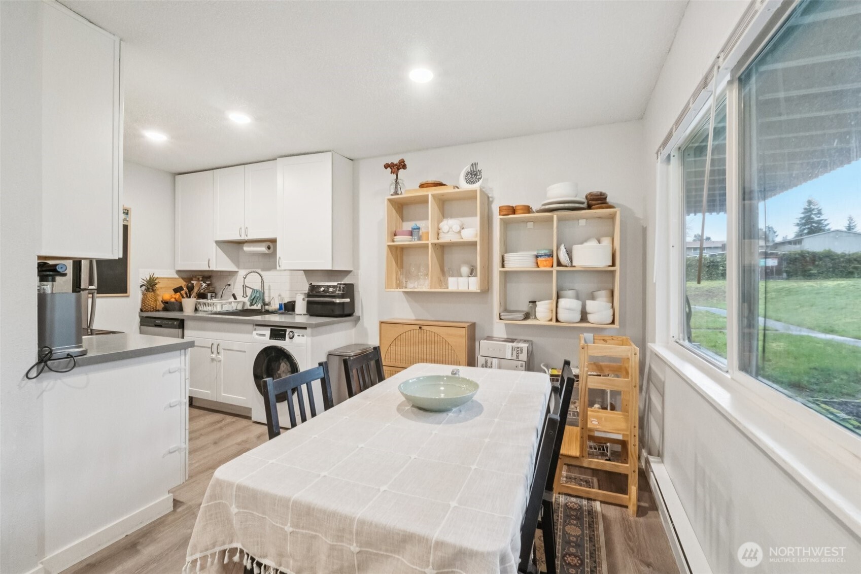 9623 South 248th Street, Unit G5 Kent, WA 98030 - Photo 7 of 23 a dining room with stainless steel appliances furniture a large window and a kitchen view