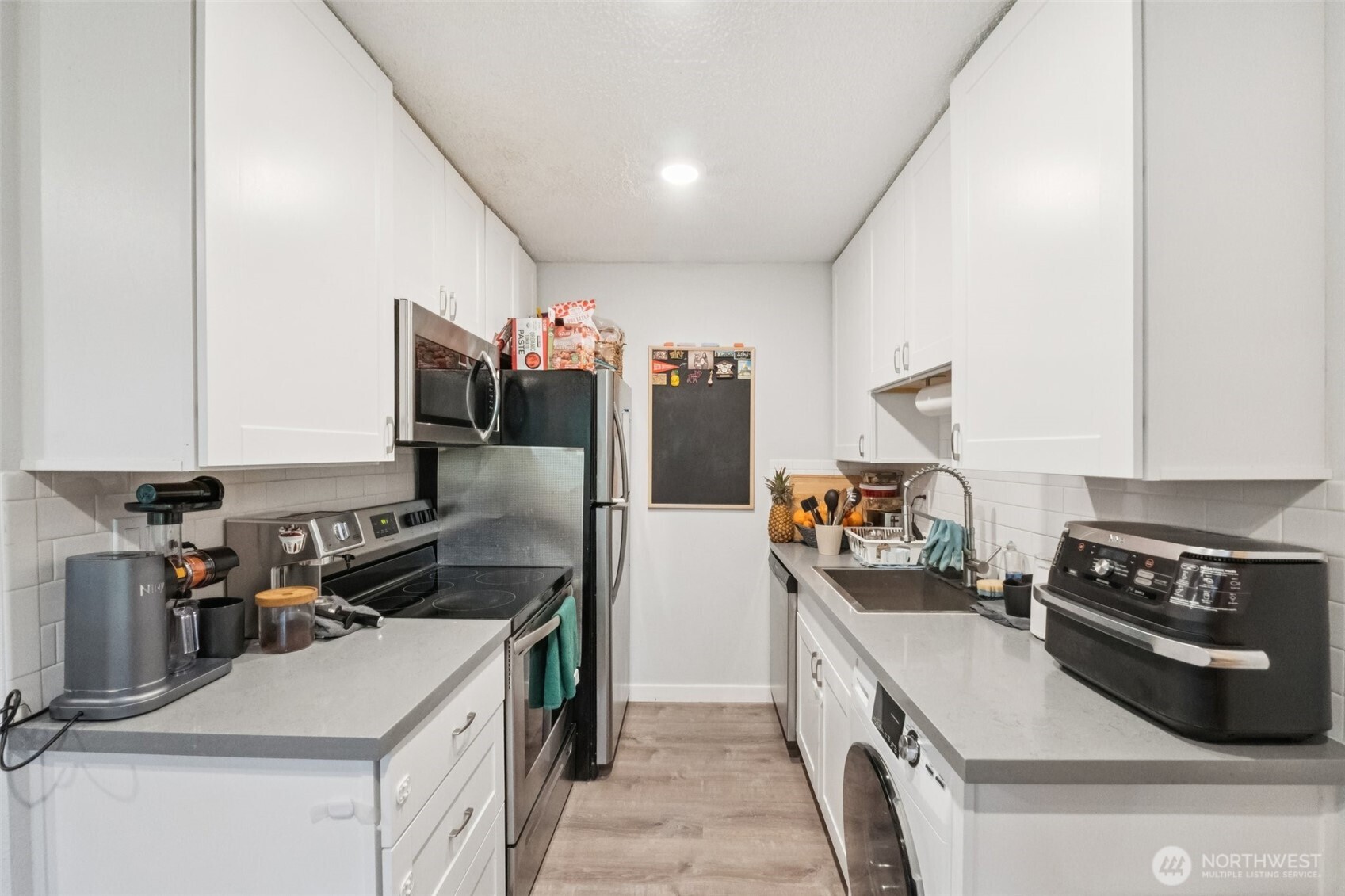 9623 South 248th Street, Unit G5 Kent, WA 98030 - Photo 9 of 23 a kitchen that has a sink a stove and a refrigerator