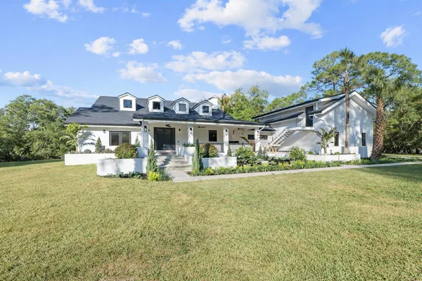 a view of a house with backyard and sitting area