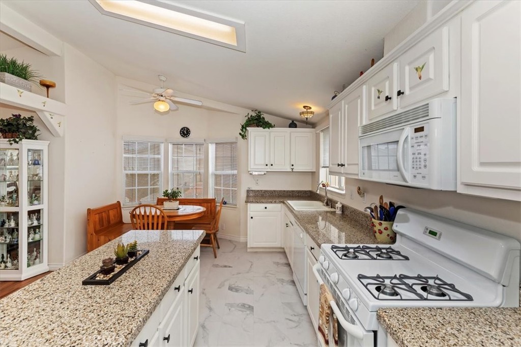 27250 Murrieta Road, Unit 298 Menifee, CA 92586 - Photo 21 of 54 a kitchen with a stove a refrigerator and wooden cabinets