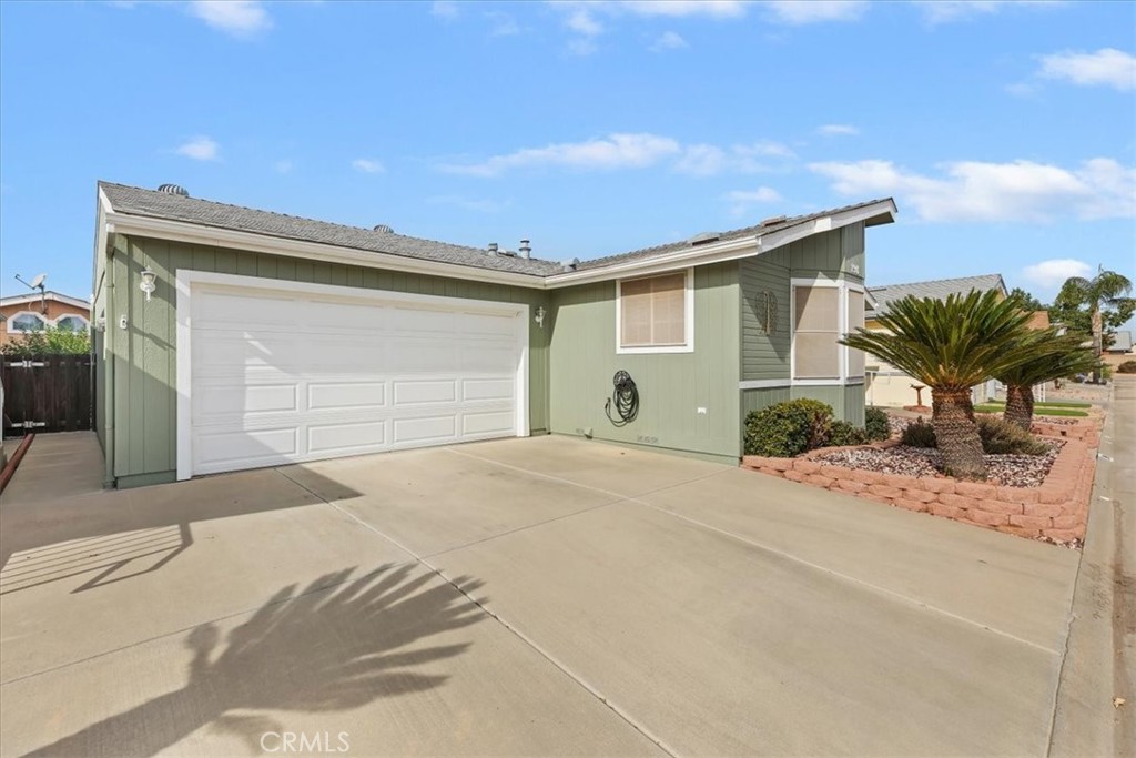 27250 Murrieta Road, Unit 298 Menifee, CA 92586 - Photo 4 of 54 a front view of a house with a yard and garage