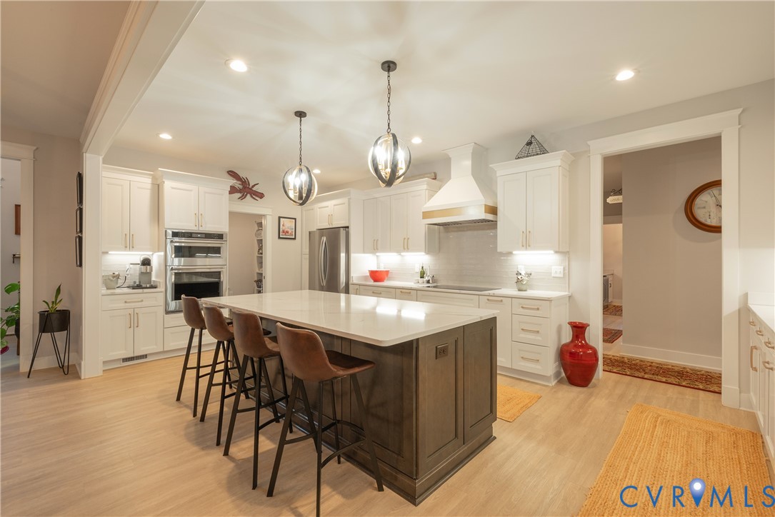 2591 Shaughnessy Road Powhatan, VA 23139 - Photo 22 of 50 a kitchen with stainless steel appliances kitchen island granite countertop a stove a sink dishwasher and a refrigerator with wooden floor