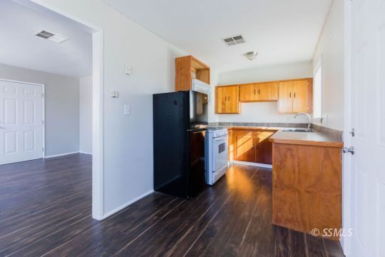 249 North Alvord Street Ridgecrest, CA 93555 - Photo 32 of 39 a kitchen with stainless steel appliances granite countertop a refrigerator a sink and wooden floor