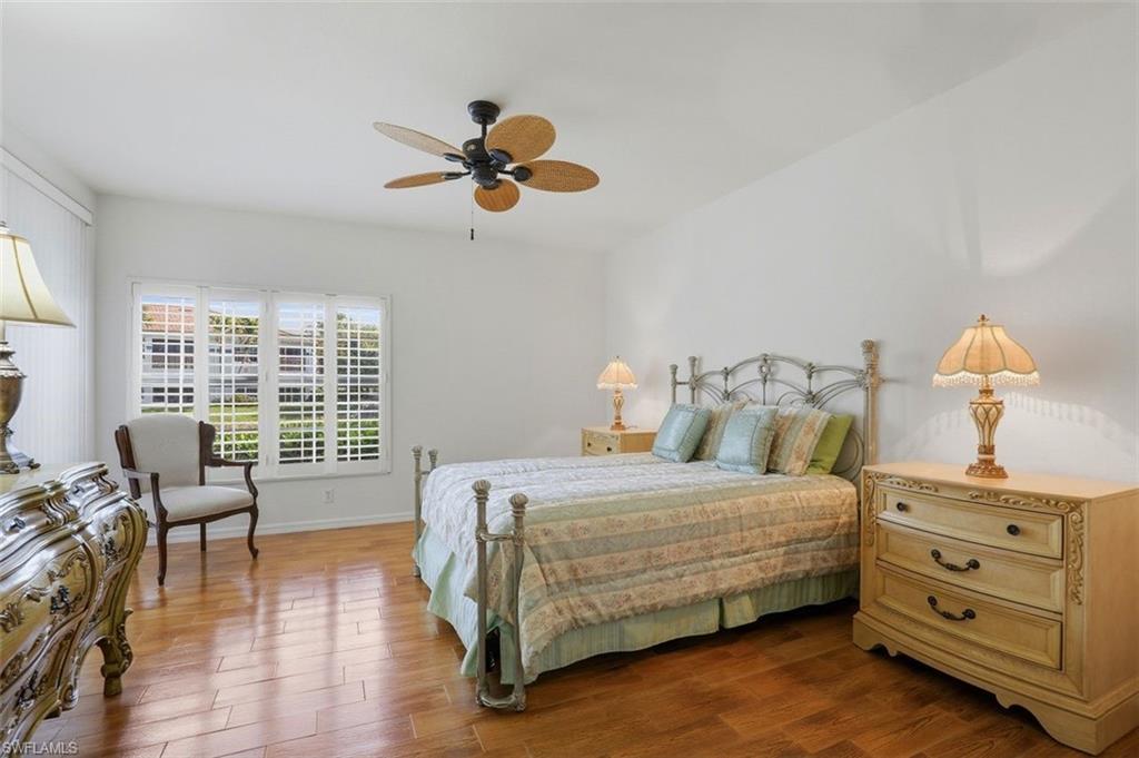 23820 San Marino Road, Unit 102 Estero, FL 34135 - Photo 14 of 28 Bedroom featuring wood finished floors and a ceiling fan