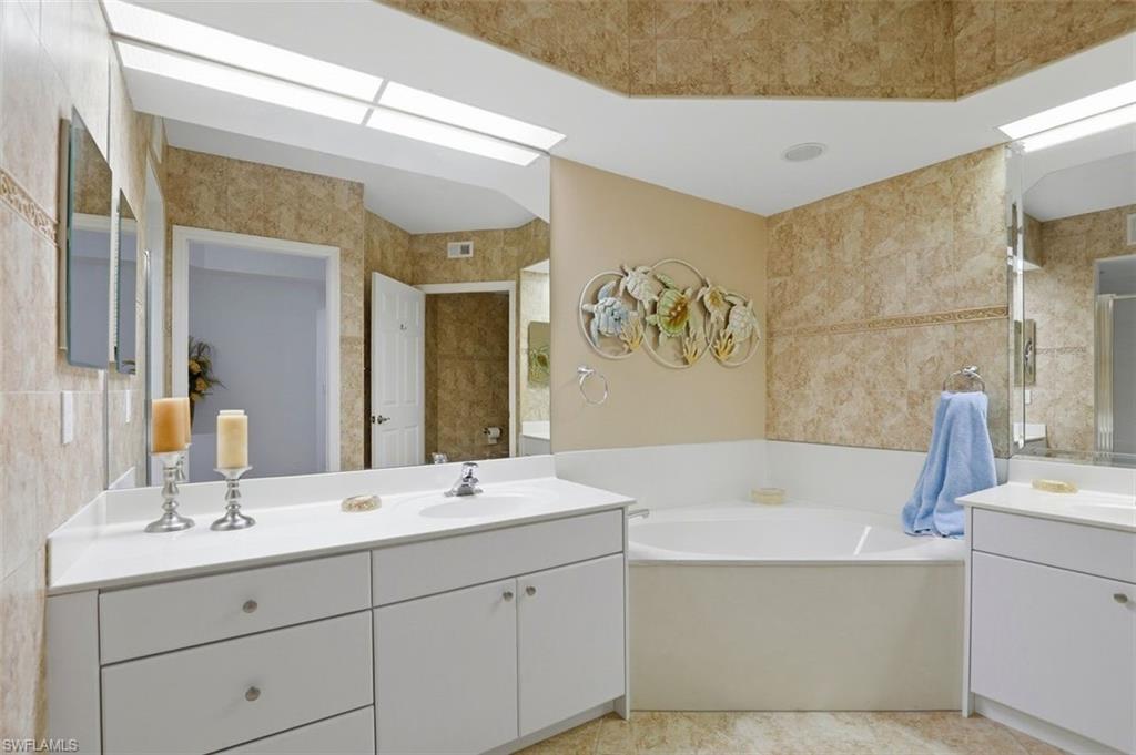 23820 San Marino Road, Unit 102 Estero, FL 34135 - Photo 16 of 28 Bathroom featuring a bath and two vanities