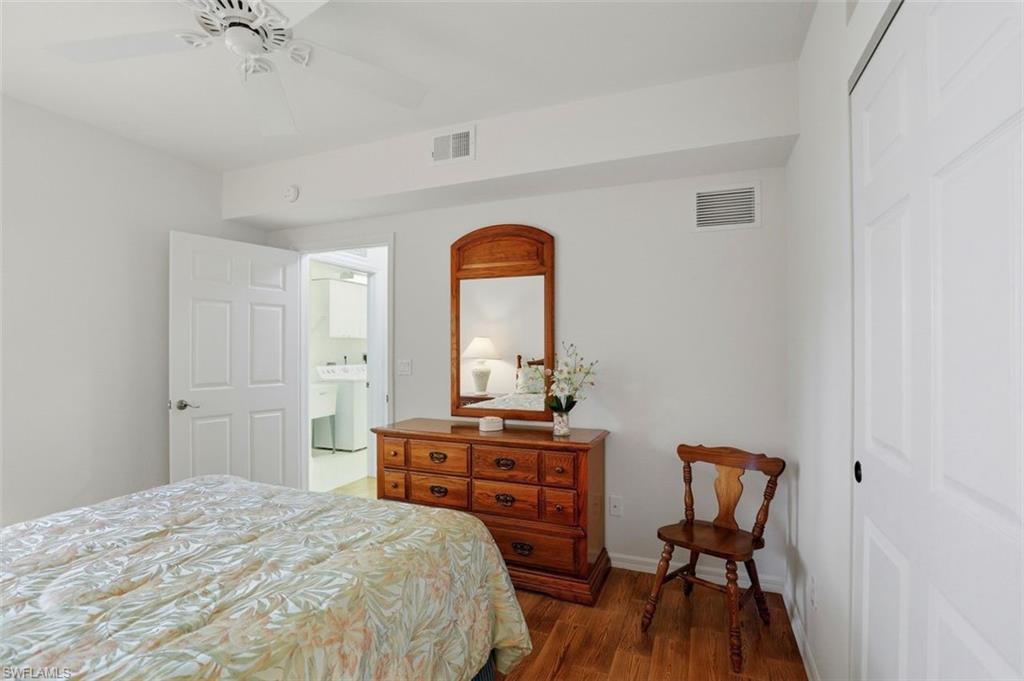 23820 San Marino Road, Unit 102 Estero, FL 34135 - Photo 20 of 28 Bedroom with a closet, dark wood-style floors, washer / clothes dryer, and ceiling fan