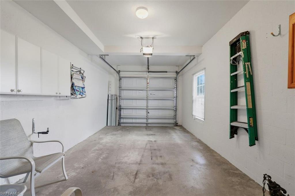23820 San Marino Road, Unit 102 Estero, FL 34135 - Photo 26 of 28 Garage featuring a garage door opener