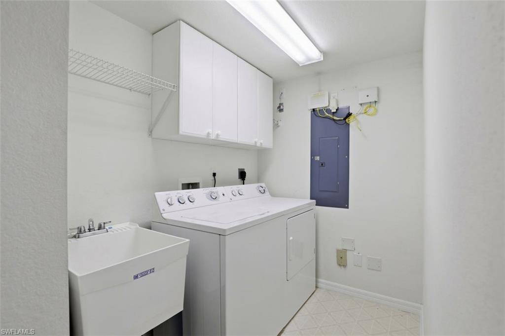 23820 San Marino Road, Unit 102 Estero, FL 34135 - Photo 28 of 28 Laundry area featuring light floors, electric panel, cabinet space, and washer and dryer