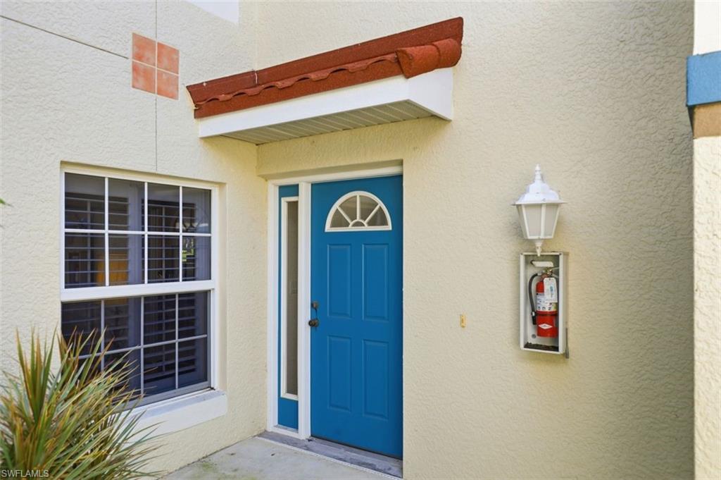 23820 San Marino Road, Unit 102 Estero, FL 34135 - Photo 5 of 28 Doorway to property featuring stucco siding