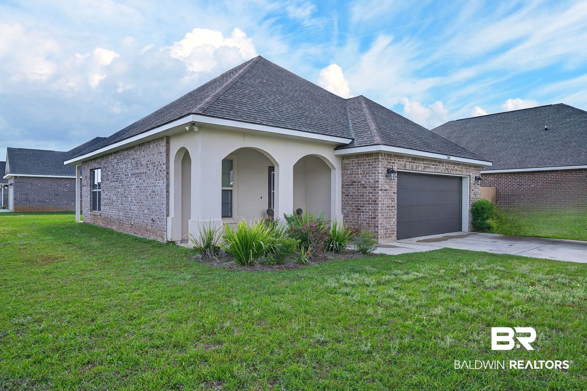 1084 Stella Road Foley, AL 36535 - Photo 2 of 31 View of side of home featuring brick siding, a lawn, an attached garage, driveway, and stucco siding