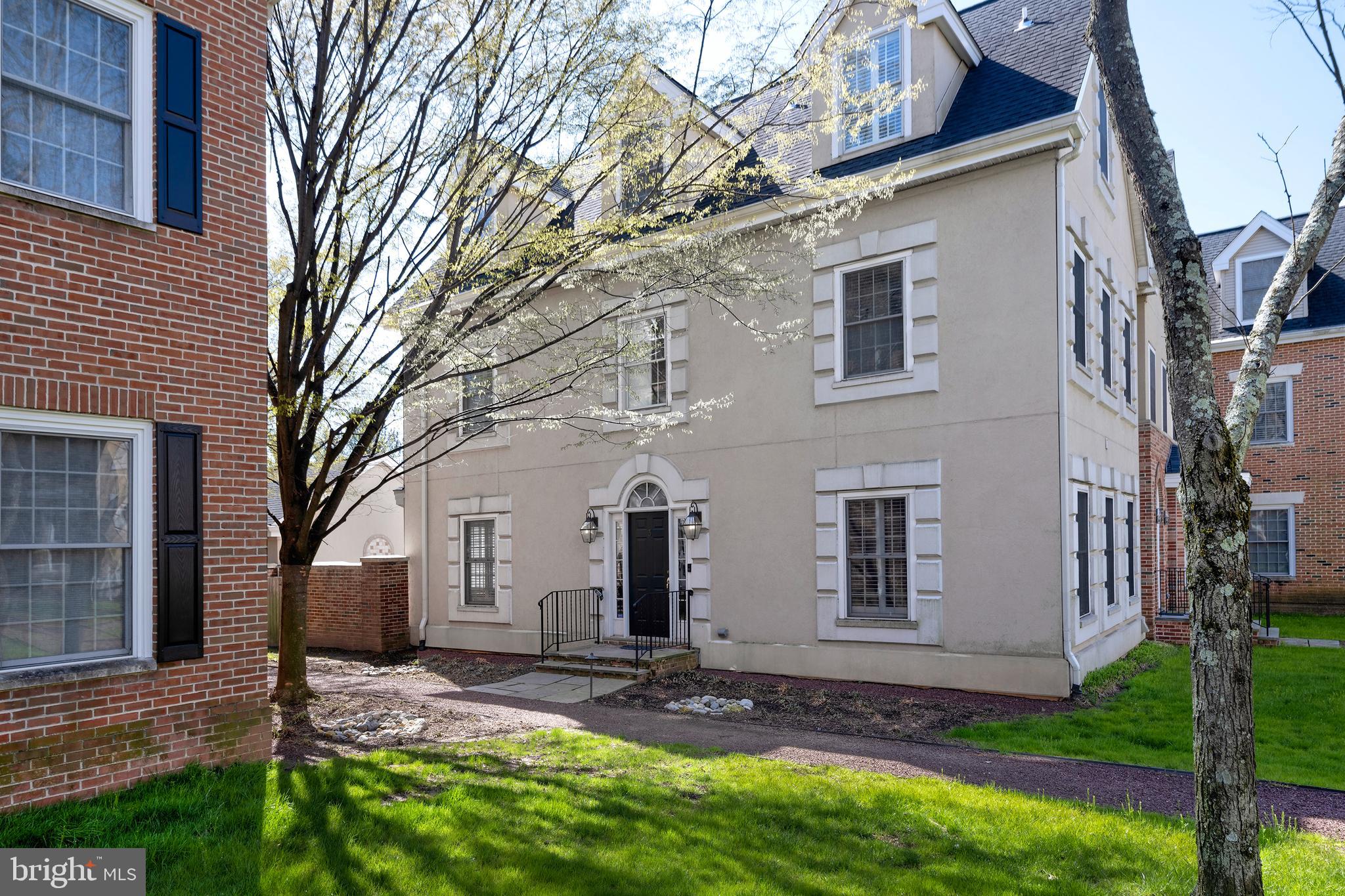 a view of a white house with a yard and large tree
