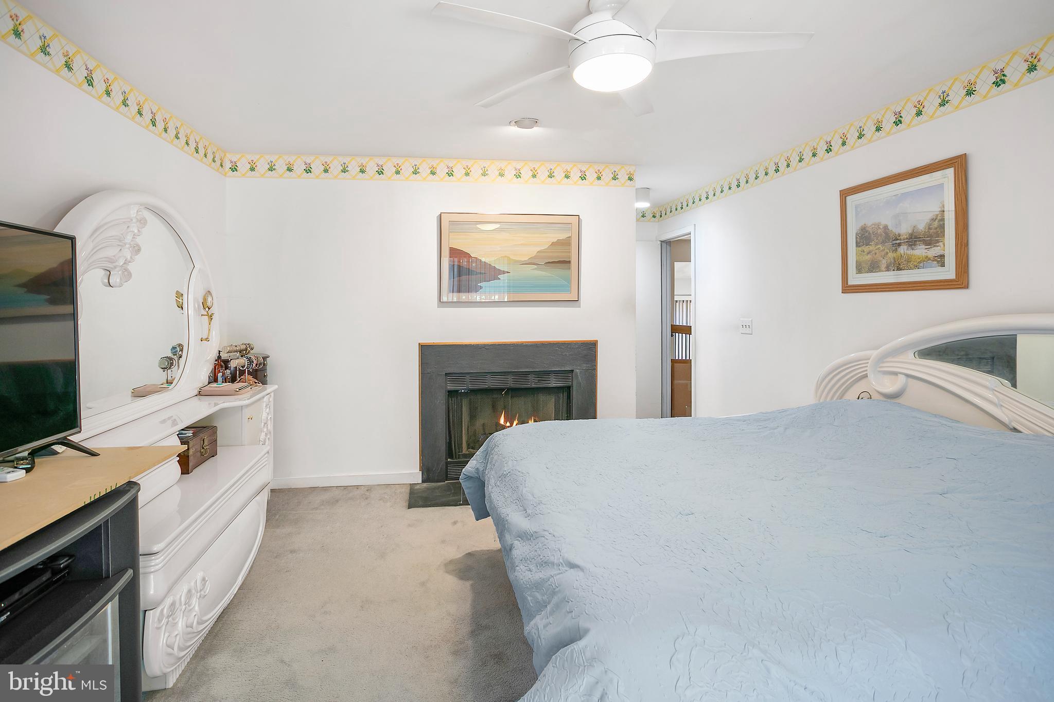 2213 Cedar Cove Court Reston, VA 20191 - Photo 9 of 40 a spacious bedroom with a bed and a flat screen tv